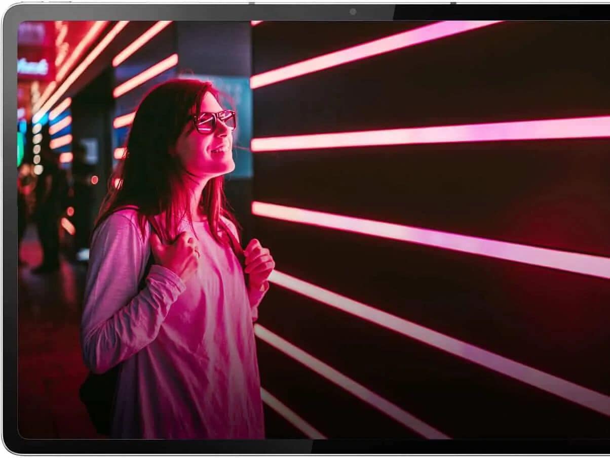 Woman staring at wall with illuminated pink stripes