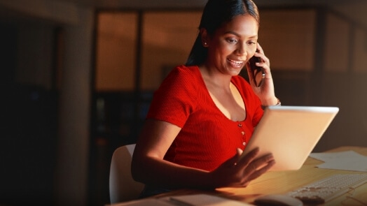 IT professional woman talking on phone while viewing tablet